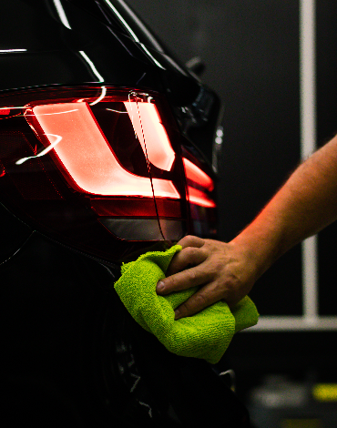 cleaning car's back headlight with a microfiber cloth